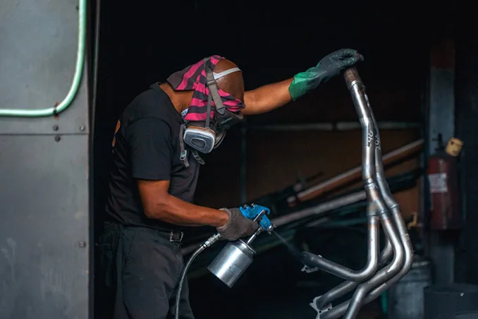 A worker finishing an exhaust manifold at Viper